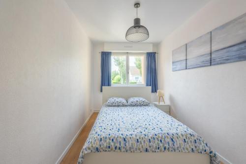 une chambre avec un lit et une fenêtre dans l'établissement L'Ancre Marine - Appt à 100m de la plage, à Courseulles-sur-Mer