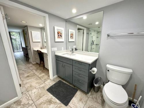a bathroom with a toilet and a sink and a mirror at Poolside Breeze Retreat in Key West