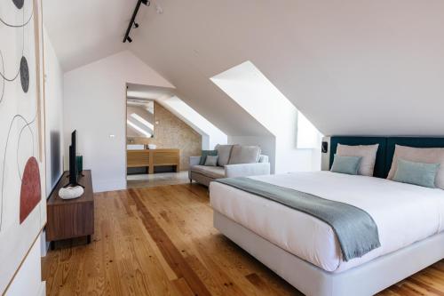 a bedroom with a large white bed and a couch at The House on the Pink Street in Lisbon in Lisbon