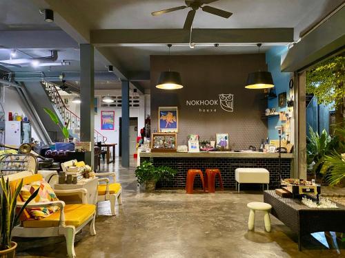 a restaurant with tables and chairs and a counter at Nokhook House in Trang
