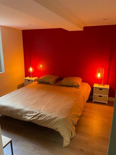 een slaapkamer met een groot bed met een rode muur bij Gîte Normandie in Lisieux
