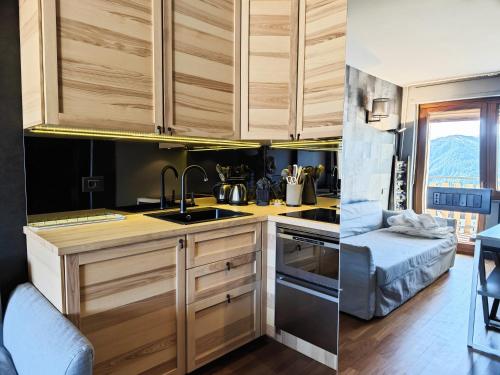 a kitchen with wooden cabinets and a sink at Hostdomus - Oak Luxury Suite in Sestriere