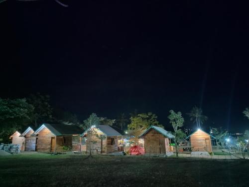 uma fila de casas iluminadas à noite em Beach Camp Lombok em Sekotong