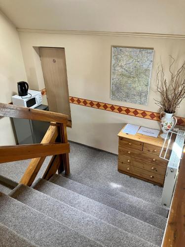 a room with a staircase with a table and a cabinet at Penzion Tereza in Janov nad Nisou