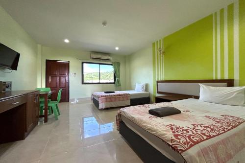 a hotel room with two beds and a desk and a kitchen at SB Park Mansion in Phuket Town