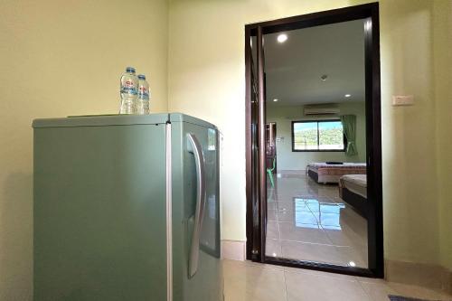 Un refrigerador de acero inoxidable en una sala de estar con espejo. en SB Park Mansion, en Phuket