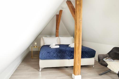 Schlafzimmer mit Himmelbett und blauer Bettwäsche in der Unterkunft Schlossberg Residences - XXL-Design-Apartment mit Schlossblick für bis zu 10 Personen in Schwetzingen