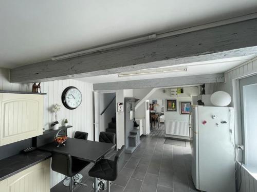 een keuken met een koelkast en een klok aan de muur bij Maison de ville cosy et chaleureuse 