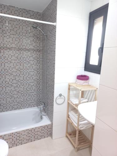 La salle de bains est pourvue d'une baignoire, d'un lavabo et d'une douche. dans l'établissement Apartament Ca l'Eudald Parelles, à Besalú