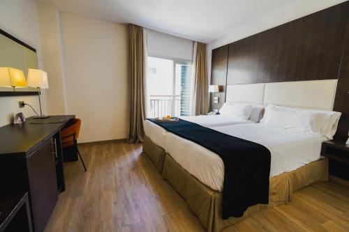 a hotel room with a large bed and a desk at Hotel Taburiente S.C.Tenerife in Santa Cruz de Tenerife
