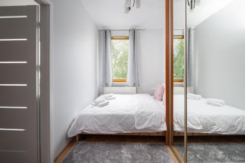 a bedroom with a mirror and a bed at Obrzeżna Standard Apartment in Warsaw