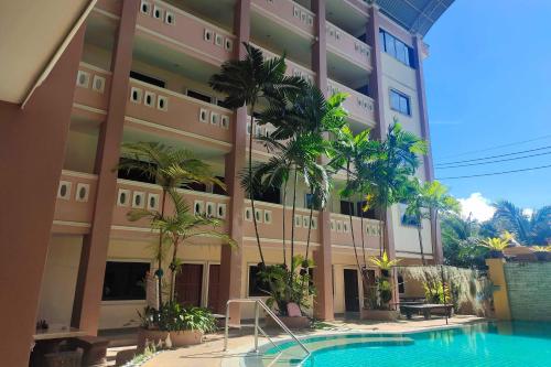 a hotel with a swimming pool in front of a building at SB Park Mansion in Phuket