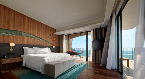 Schlafzimmer mit einem Bett und Meerblick in der Unterkunft PARKROYAL Langkawi Resort in Pantai Cenang