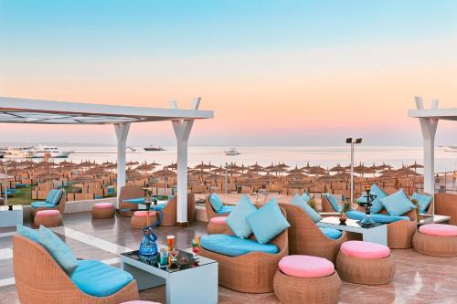 Pickalbatros White Beach Resort - Hurghada في الغردقة: اطلالة على الشاطئ من منتجع فيه كراسي وطاولات