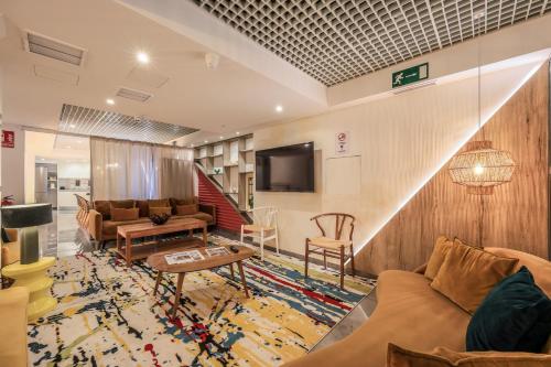 sala de estar con sofá y TV en AmazINN Places Chamberi, en Madrid