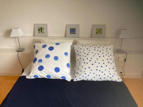 a bed with blue and white pillows in a room at Gîte Bon Accueil, 3 étoiles, Souzay-Champigny 49 in Souzay-Champigny