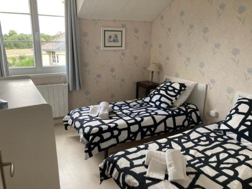 une chambre avec deux lits et une fenêtre dans l'établissement Gîte Bon Accueil, 3 étoiles, Souzay-Champigny 49, à Souzay-Champigny