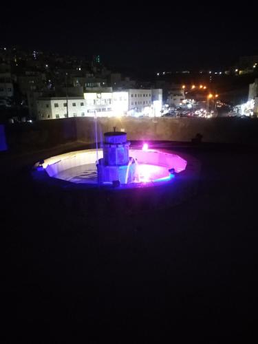 a fountain with purple lights in a city at night at شقة فاخرة مع مطل luxerious with nice view in Amman