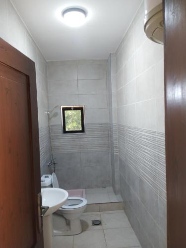 La salle de bains est pourvue de toilettes et d'un lavabo. dans l'établissement شقة فاخرة مع مطل, à Amman