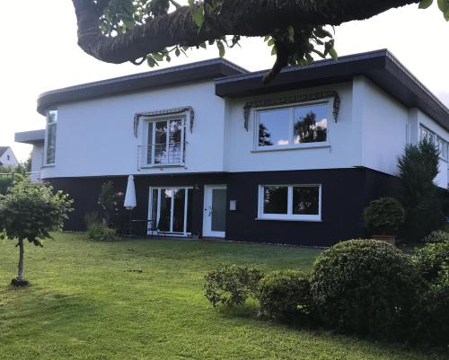 a white and black house with a yard at Woanders zu Hause 4 Sterne FeWo in Kölbingen