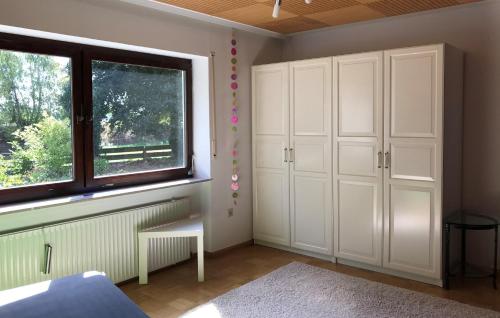 a bedroom with white cabinets and a window at Woanders zu Hause 4 Sterne FeWo in Kölbingen