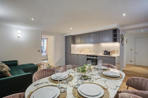 une salle à manger avec une table et des chaises et une cuisine dans l'établissement Apartment Saint Germain des Près by Studio prestige, à Paris