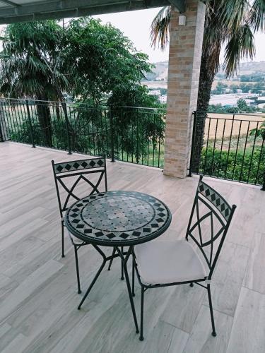 two chairs and a table on a patio at Le Colline Del Conero in Monte Gallo