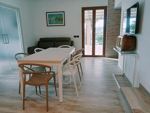 a dining room with a white table and chairs at Le Colline Del Conero in Monte Gallo