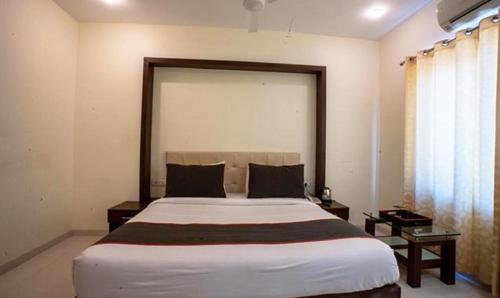 Un dormitorio con una cama grande y una ventana en FabHotel Prime Lorven, en Visakhapatnam