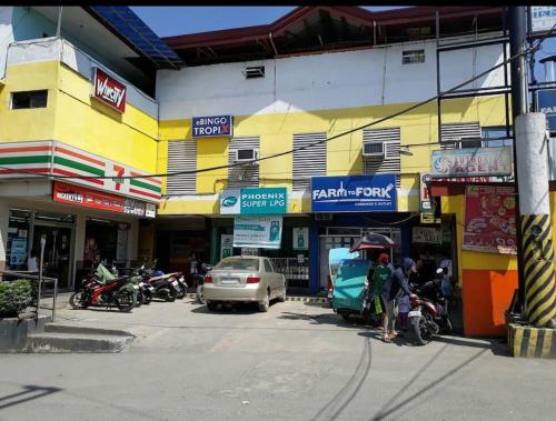 a group of shops on a street with cars and motorcycles at Montalban RestHouse 1 AC BR TownHouse in Rodriguez