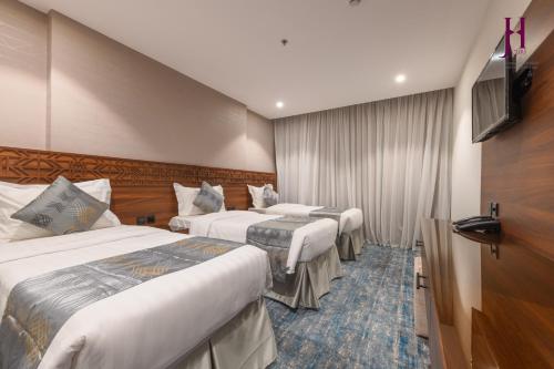 Säng eller sängar i ett rum på Manazel Al Zaireen Hotel