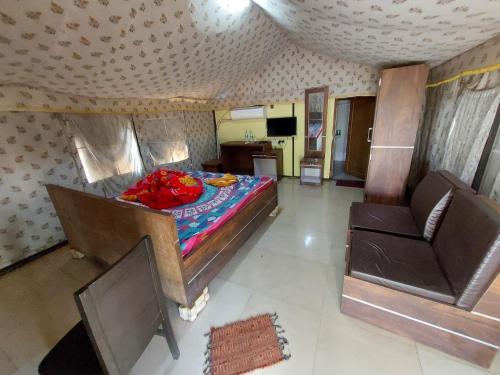 a bedroom with a bed and two chairs in it at Baranti Eco Tourism Resort, Muradi 