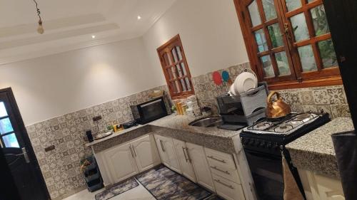 uma cozinha com um fogão e um lavatório em host-house em Marrakech