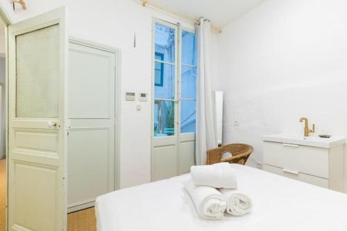 ein weißes Schlafzimmer mit einem weißen Bett und einem Waschbecken in der Unterkunft Superbe Appart Marseille/Vieux Port/grande Loggia in Marseille