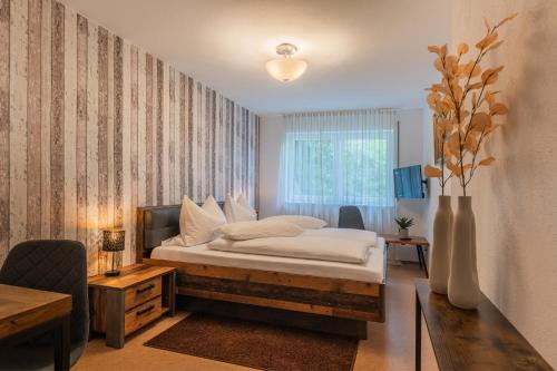 una camera con letto e vaso con fiori di Hotel am Kirchplatz a Überlingen