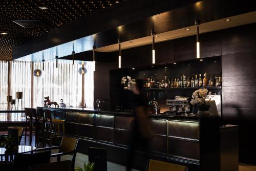 a person walking past a bar in a restaurant at Caesar Premier Tiberias Hotel in Tiberias