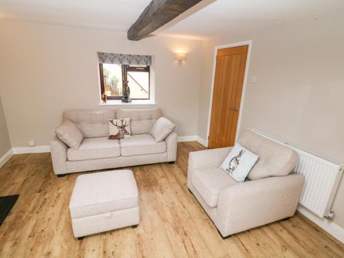 a living room with a couch and a chair at Smithy Cottage in Dronfield