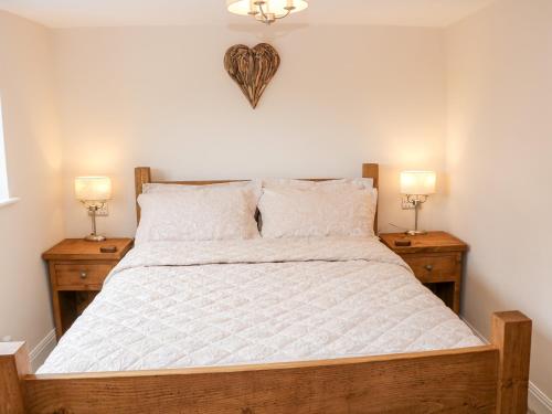 a bedroom with a large bed with two night stands at Smithy Cottage in Dronfield