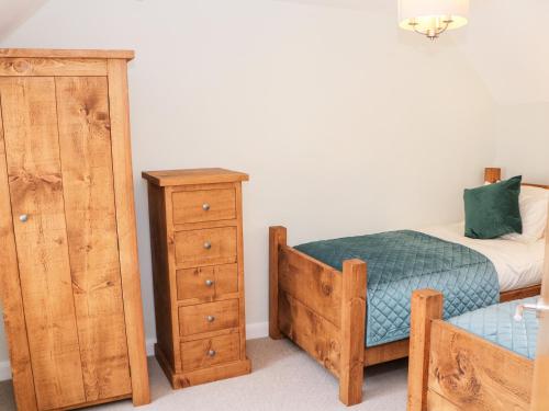 a bedroom with a bed and a dresser at Smithy Cottage in Dronfield