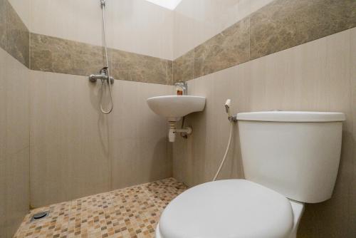 a bathroom with a white toilet and a sink at RedDoorz near Surabaya Town Square in Surabaya