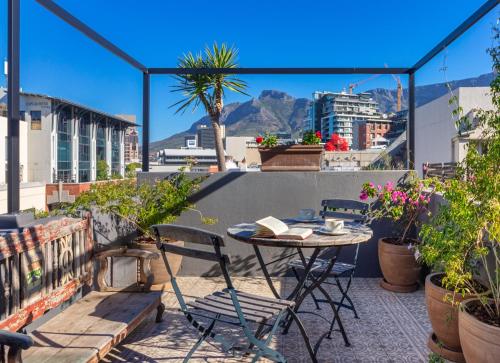 a patio with a table and chairs on a roof at The Grey Hotel in Cape Town