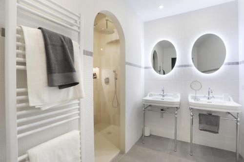 a white bathroom with two sinks and a shower at Apartment Saint Germain des Prés by Studio prestige in Paris