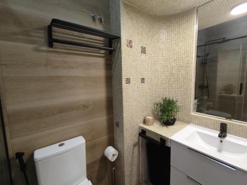 uma casa de banho com um WC branco e um lavatório. em T1 Rosa dos Ventos, A/C & Terrace - Casas & Papéis em Armação de Pêra