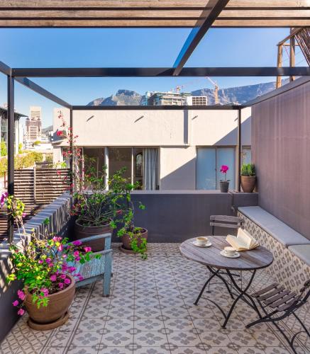 an outdoor patio with tables and potted plants at The Grey Hotel in Cape Town