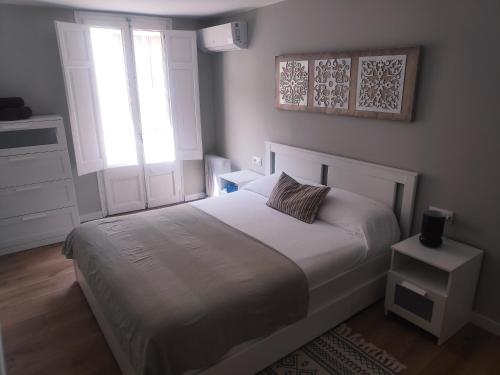 een slaapkamer met een wit bed en een raam bij Petit Bruixó Camprodon in Camprodon