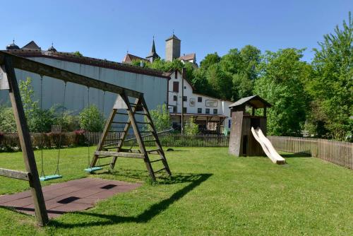a playground with a slide and a play structure at Brauereigasthof Rothenbach in Aufseß