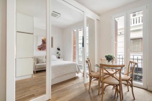sypialnia z łóżkiem i stołem z krzesłami w obiekcie Room Canalejas w Madrycie