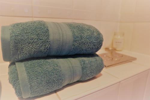 uma pilha de toalhas sentadas num balcão na casa de banho em 2BR Apt in Crawley w Parking - Near Gatwick em Crawley