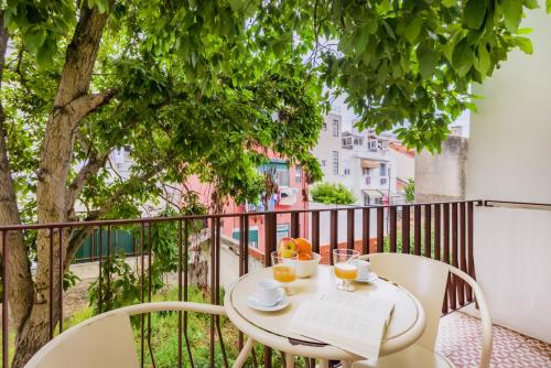 a table with a laptop and two chairs on a balcony at Casa da Graça Lisbon Hideout in Lisbon