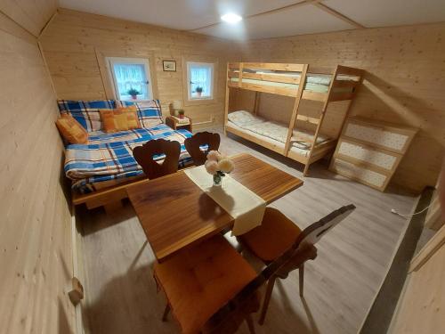 a room with a dining table and a bunk bed at Roubenka u potoka Výprachtice in Výprachtice